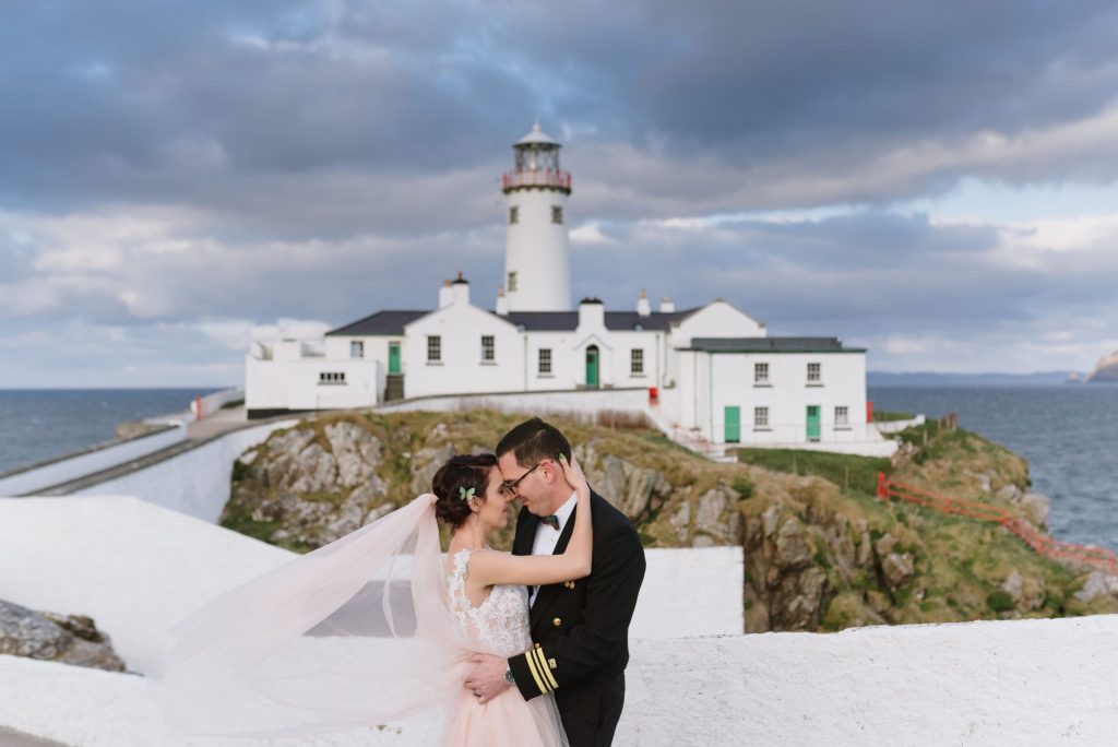 wedding photos of husband and wife in front of lighthouse